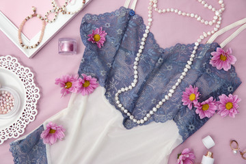 Beautiful female negligee and accessories with flowers on lilac background