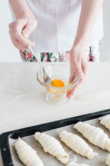 Young beautiful woman preparing homemade croissants
