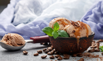 Homemade coffee ice cream with chocolate, caramel and mint. Selective focus