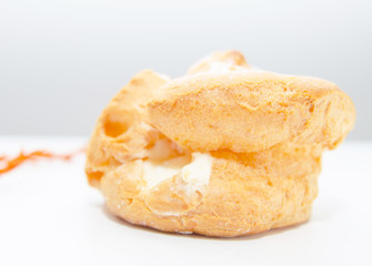 Profiteroles stuffed with pastry cream on white desk in cafe