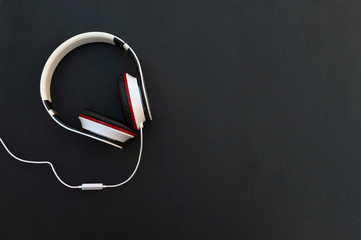 Headphones and cable on a dark background. Top view.