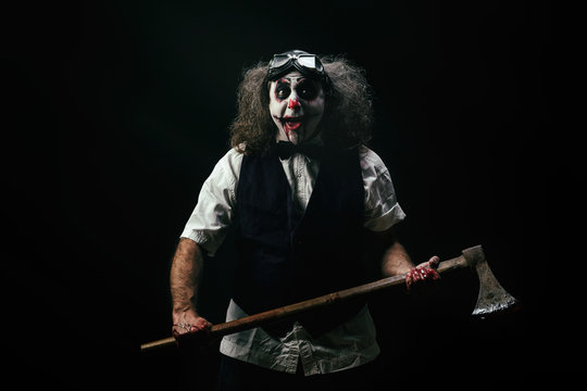 Portrait d'un clown criant, une hache ensanglant&eacute; dans ses mains