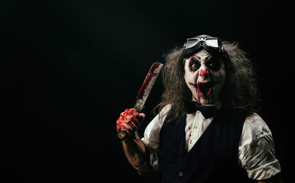 Portrait d'un clown criant, un couteau ensanglanté dans sa main