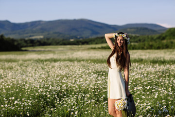 Woman enjoying daisy field, nice female lying down in meadow of flowers, pretty girl relaxing outdoor, having fun, holding plant, happy young lady and spring green nature, harmony concept