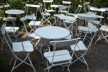 Empty white chairs and tables at a café outside