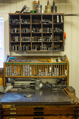 A typographer's workplace in an old print shop. Fonts and types in lead of all sizes are well sorted in small compartments