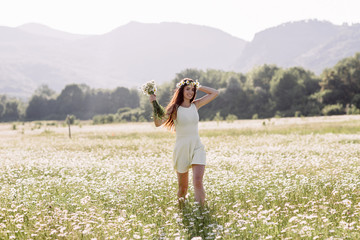 Woman enjoying a field of daisies, beautiful woman lying in a meadow of flowers, beautiful girl relaxing outdoors, having fun, holding plant, happy young lady and spring-green nature, harmony concept.