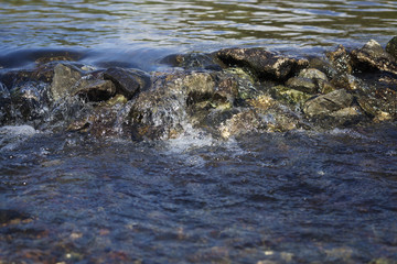 Stream flowing over stones rough rocks