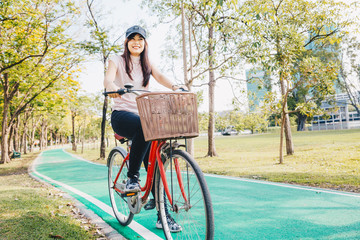 Asian active women with bicycle in city park