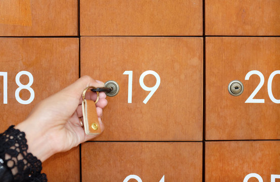 Hand holding key to open Mailbox.