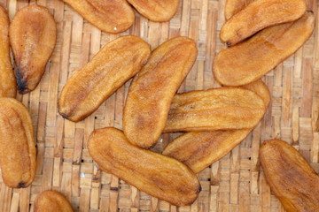 Sun dried bananas on bamboo weave background.