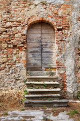 Fototapeta na wymiar Old wooden door of a run down house in Tuscany, Italy.