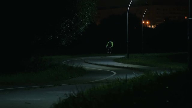 Cyclist rides through the night park
