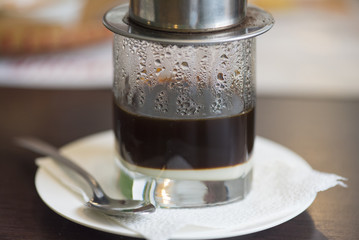 Vietnamese coffee, close-up glass mug with traditional Asian black coffee and sweet milk