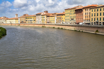 Fototapeta na wymiar Bright italian houses on the Arno river in Pisa, Tuscany, Italy.
