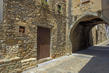 Fototapeta na wymiar Angles pueblo de Girona calle principal con arcada de piedra muy antigua