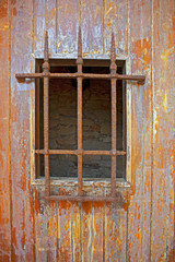 ventana con reja antigua y oxidad cerca del mar en Girona Cataluña,España