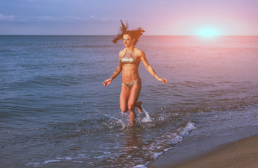 Fit girl jumping in sea.