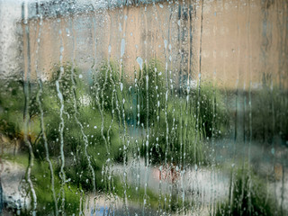 Wet window ready for cleaning. Water and liquid  spray dripping. Blurred background.