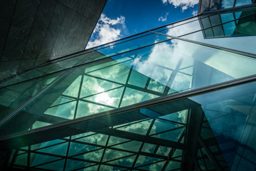 Underside panoramic and perspective view to steel blue glass high rise building with reflections