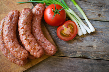 
Sausages with vegetables on a wooden texture