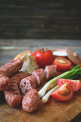
Sausages with vegetables on a wooden texture