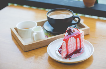 strawberry crape cake with strawberry sauce and hot coffee in cozy outdoor cafe.(selective focus)