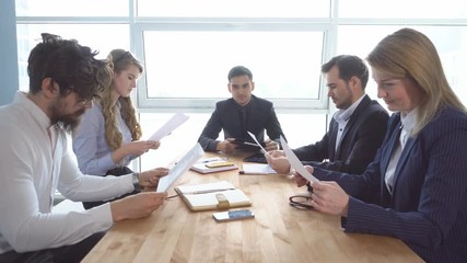 Colleagues look through documents. a business meeting. Group of young businessman at the negotiating table in the office.
