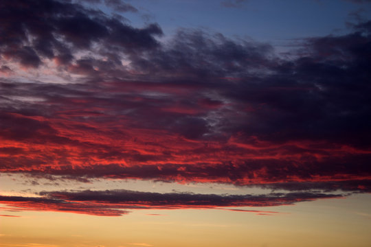 Red cloudy sky at sunset of a summer day © Nikolay