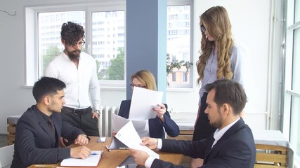 Successful business man at a meeting in the office. Colleagues are sitting at the negotiating table. Conclusion of the transaction and signing of the cooperation agreement.
