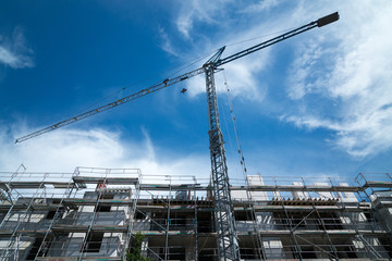 Blue construction crane with a new building in front