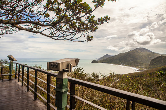 Vintage scenic binocular viewer overlooking mountainous coastline