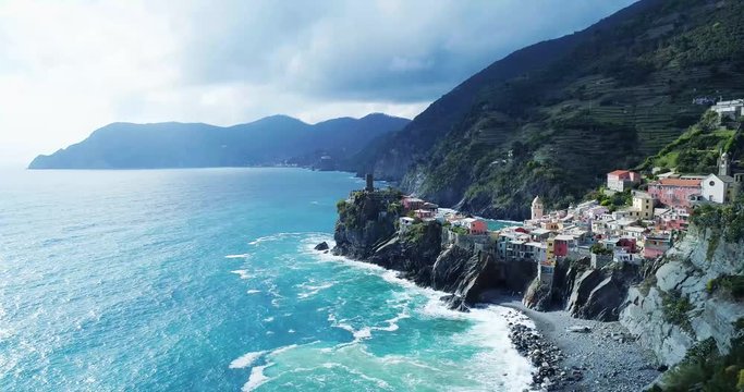 aerial view of travel landmark destination Vernazza, a small mediterranean sea town, Cinque terre National Park, Liguria, Italy. Afternoon sunny and cloud weather. 4k aerial drone orbit video shot