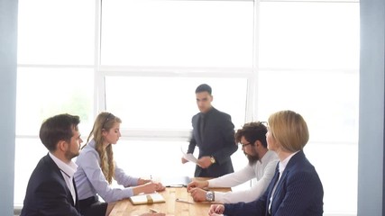 Business meeting and negotiations of young businessman. Chief holds a meeting in the office. Colleagues discuss the startup