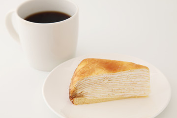 お皿にのせたミルクレープとホットコーヒー 白背景