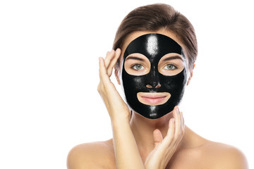 Woman with purifying black mask on her face