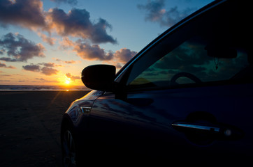 Blue sport sedan under dusk lights at sand beach
