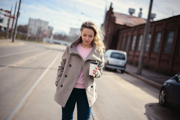Fototapeta na wymiar Woman walking down and drinking coffee