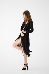 Fototapeta premium Attractive young lady in black underwear, high heele shoes and transparent dressing gown posing.