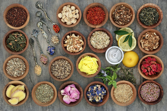 Healthy herb tea selection in wooden bowls and old spoons and strainer, teas also used in alternative medicine.