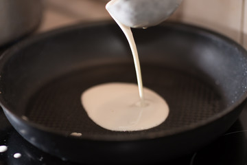 Cooking pancakes on Shrove Tuesday in a special pan in the kitchen at home