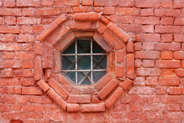 Old leaded painted wood window in an arched red brick wall in a townhouse