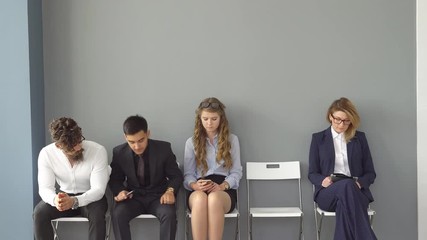 The interview for the job. Recruits are bored and enjoy the gadgets. Young people expect interviews sitting on chairs in an office building.