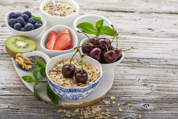 Ingredients for a healthy breakfast, nuts, oatmeal, honey, berries, fruits, blueberry, orange, pomegranate seeds, almonds, walnuts The concept of natural organic food in season Top view