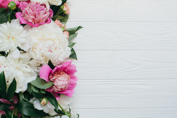 White and pink peonies on a wooden background.