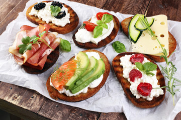 Bread Brushetta or authentic traditional spanish tapas set for lunch table. Sharing antipasti on party or summer picnic time over wooden rustic background.