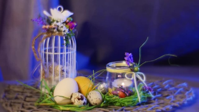 Beautiful Dekorated Easter Table With White Yellow Eggs, Covered With a Top Agg Cage, a Bottle With a Candle, Green Gras