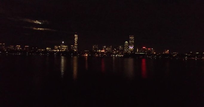 Approaching aerial shot of night Boston skyline, Charles River, Back Bay, John Hancock and Prudential tower