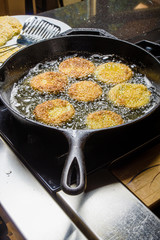 Slices of green tomato being fried