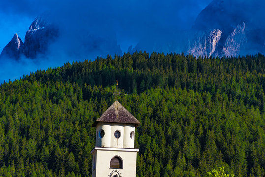 Kirchturm vor Bergen umd Wald